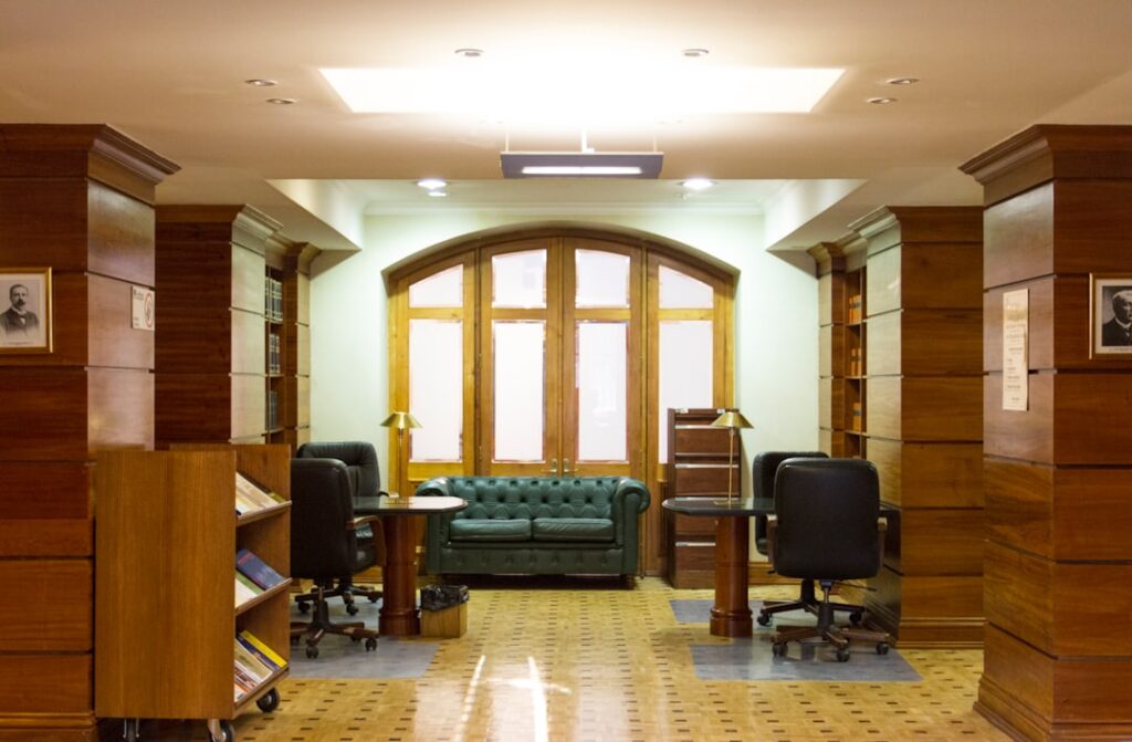 Uma Sala Com Sofa Cadeiras E Estante De Livros iaxPHnJlRnI
