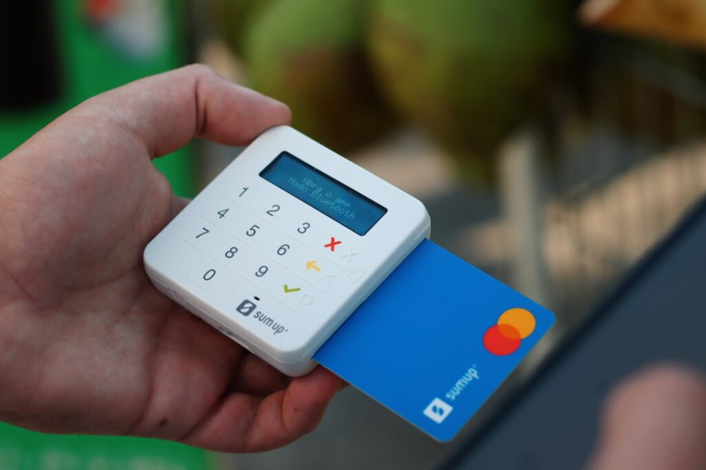 Uma Pessoa Segurando Um Cartao De Credito E Um Telefone Celular aGkR0b7hgI8