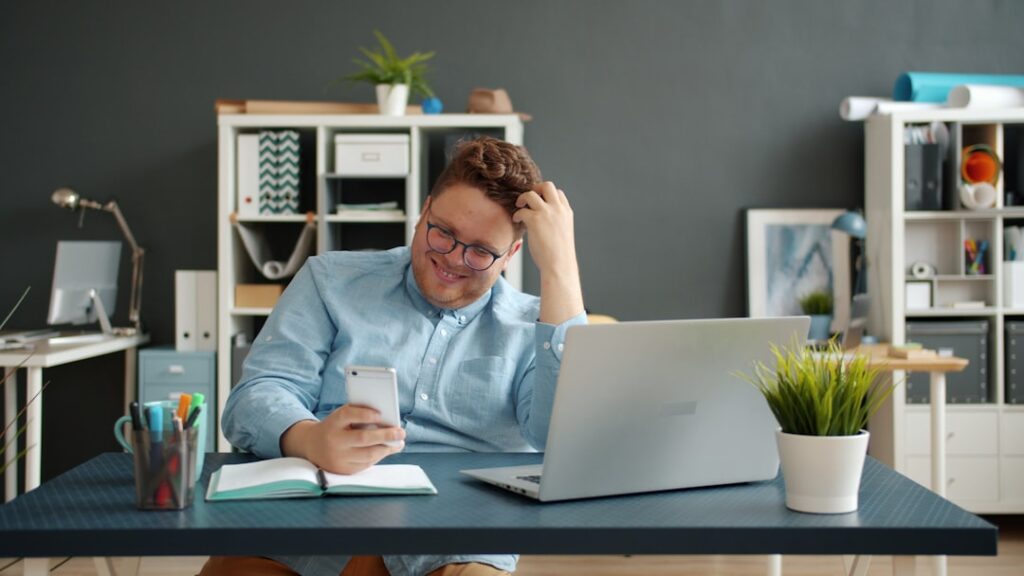Homem Rindo Enquanto Olha Para Seu Telefone Na Mesa yzpEYbCzi80