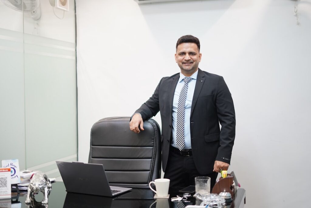 Um Homem De Terno Esta Atras De Uma Mesa De Escritorio wECq1hW92Us