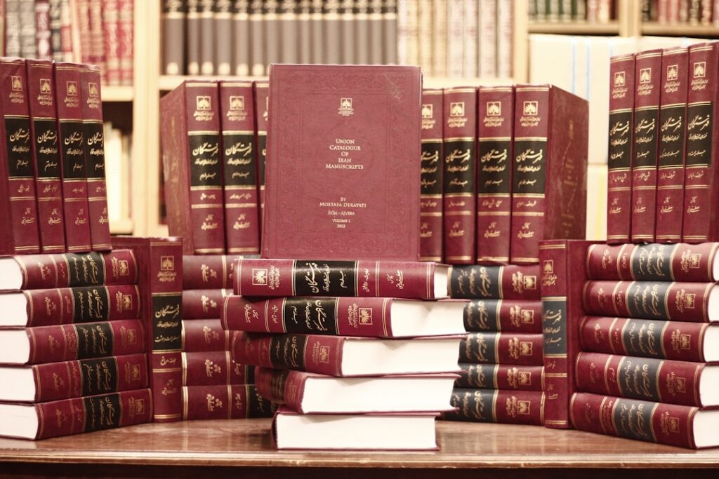 Uma Pilha De Livros Vermelhos Sentados Em Cima De Uma Mesa De Madeira LpEyM8nksws