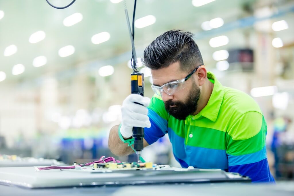 Um Homem Em Uma Fabrica Trabalhando Em Um Equipamento zekShM5_K64