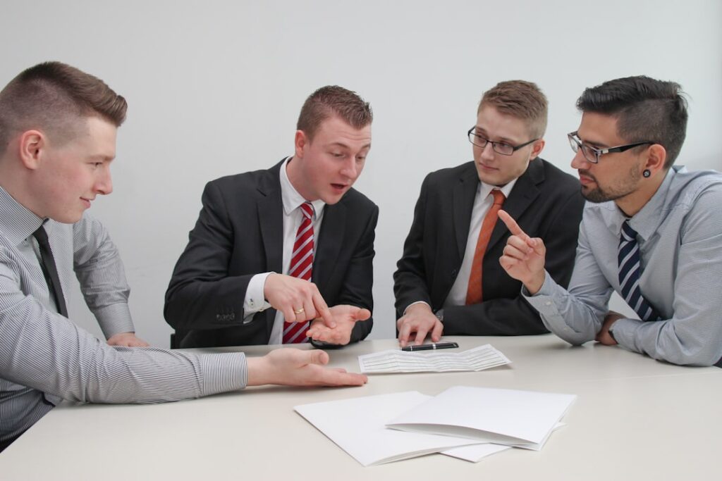Quatro Homens Sentados a Mesa Conversando 6jAq8MkbULo