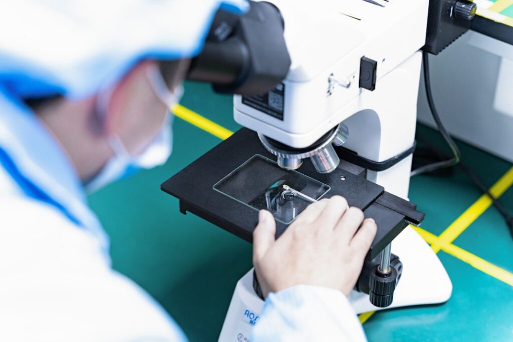 Um Homem Olhando Atraves De Um Microscopio Para Algo TqbptCWbaJg