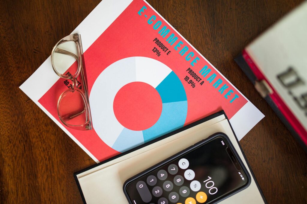 Top view of e-commerce market analysis graph with smartphone calculator and glasses for business insights.